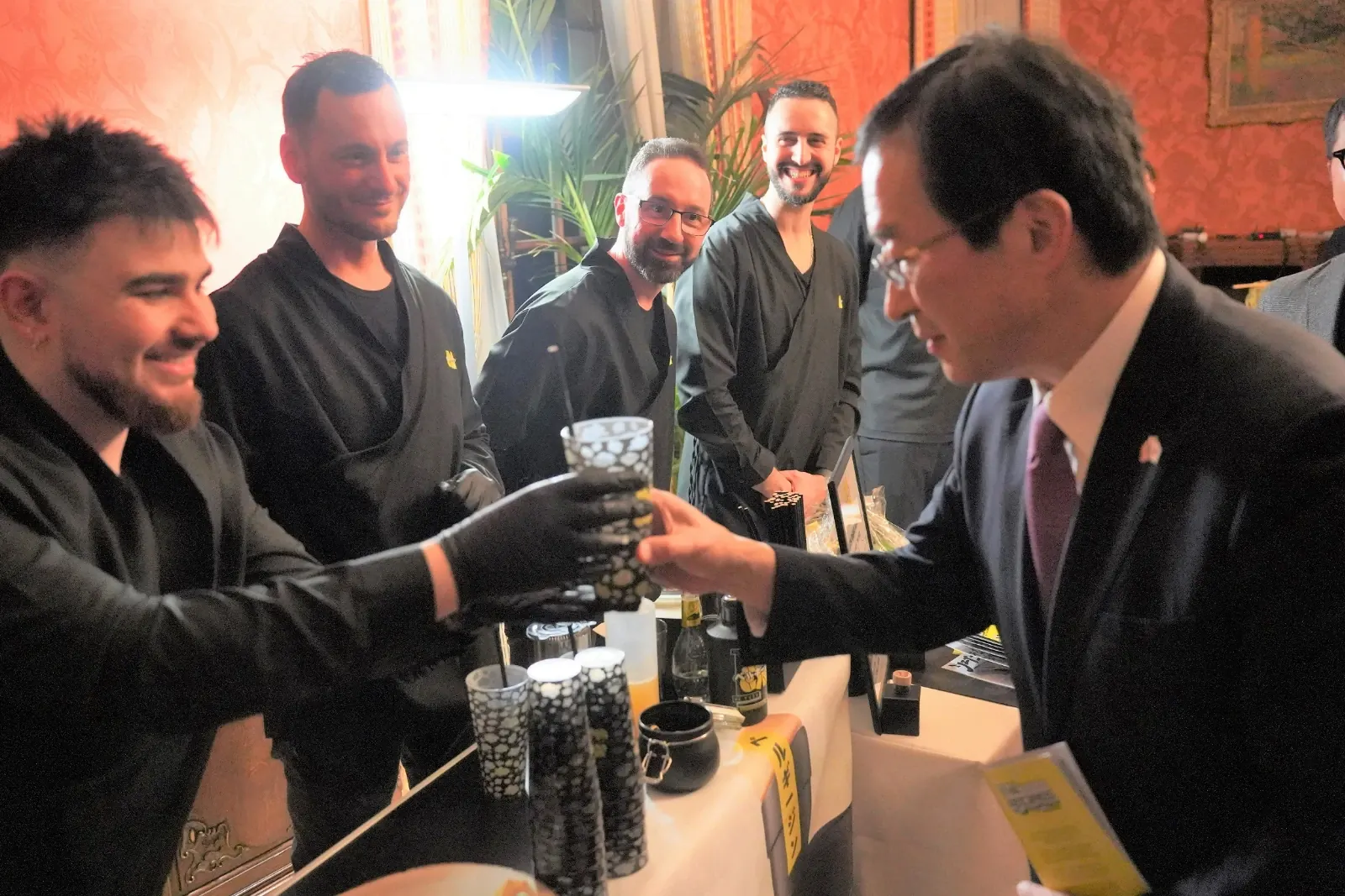 A member of the MaGin Team hands a MaGin cocktail to a Japanese guest