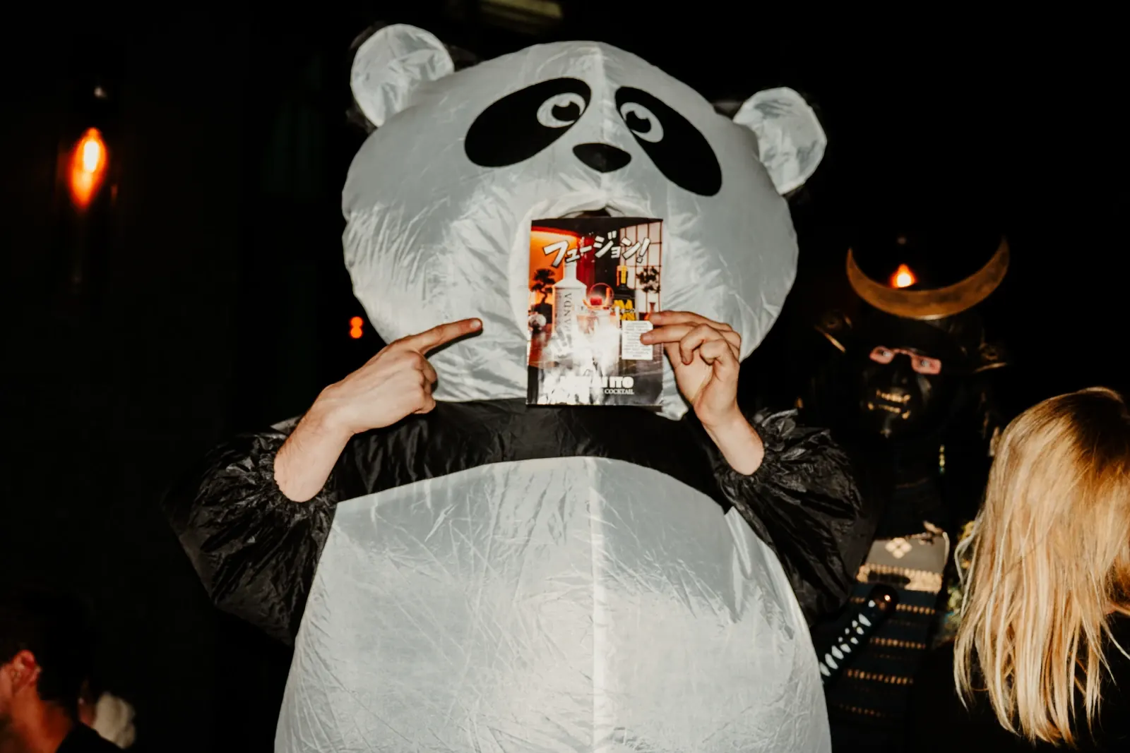 Le panda Panda Gin tient la carte du cocktail Akai Ito, le samouraï MaGin derrière lui